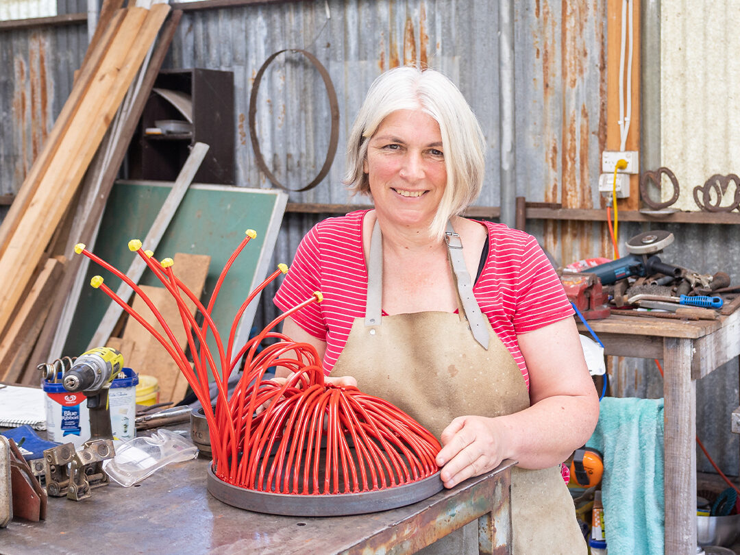 Image of Jo Caminiti with the  Ficifolia Sculpture comissioned for Drouin's Civic Park